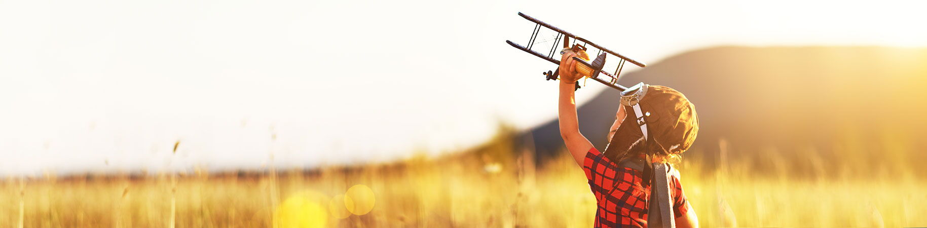 Kleiner Junge mit einem Spielzeugflugzeug im Feld