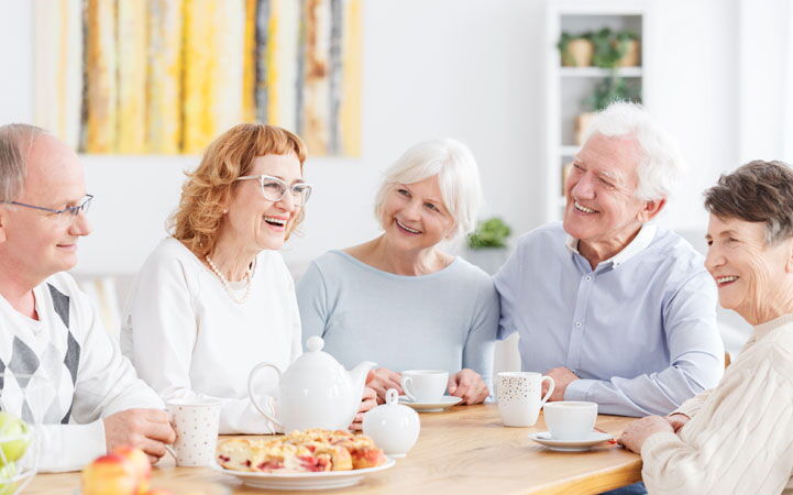 Gruppe älterer Menschen bei Kaffee und Kuchen